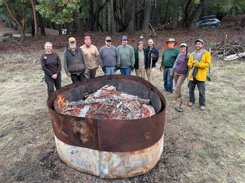 volunteers around a bio-char pit